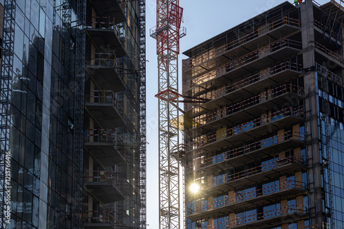 Obraz na płótnie Sunrise over an urban construction site with cranes and buildings in development, showcasing growth and industrial progress. Industrial residential construction industry. w salonie