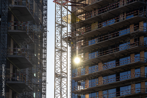 Obraz na płótnie Sunrise over an urban construction site with cranes and buildings in development, showcasing growth and industrial progress. Industrial residential construction industry. w salonie