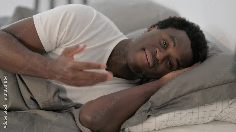 African Man Doing Video Chat while Lying in Bed African Man Doing Video Chat while Lying in Bed