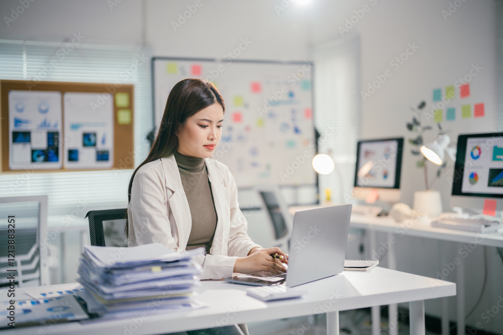 Young professional woman analyzing data and working on a computer in a modern office Young professional woman analyzing data and working on a computer in a modern office