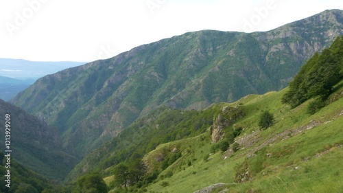 Panning shot of the landscape around Rai Hut and Raisko Praskalo waterfall in the Stara Planina Mountain. Mountain Lodge. Paradise Chalet. There is a small chapel next to the hut. Trail to Botev Peak. photo