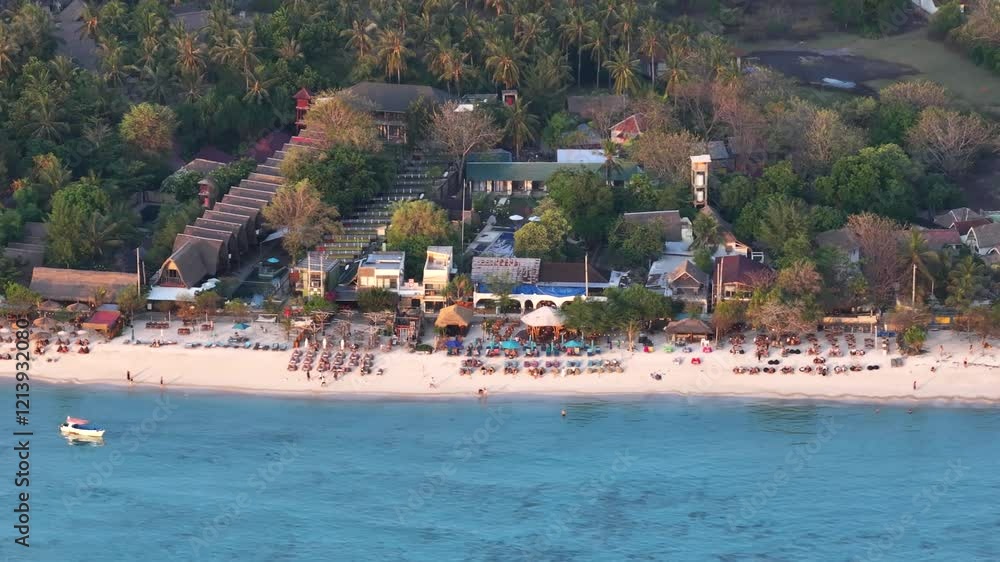 Sun beds and umbrellas on the white sandy beach in Gili Air tropical island in Indonesia. Drone Sun beds and umbrellas on the white sandy beach in Gili Air tropical island in Indonesia. Drone