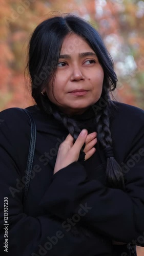 A woman stands outside in freezing weather and shaking with fever, her symptoms a vivid reminder of the seasonal health challenges.