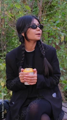 Stylish and modern, she takes a cozy coffee break, sipping her hot drink under the open sky.