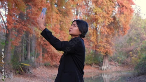 A smartphone in hand, a woman looks for a signal, facing the challenge of bad network service while exploring nature.