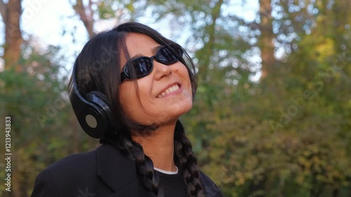 Earphones and nature set the stage for a young woman's carefree enjoyment of music and life.