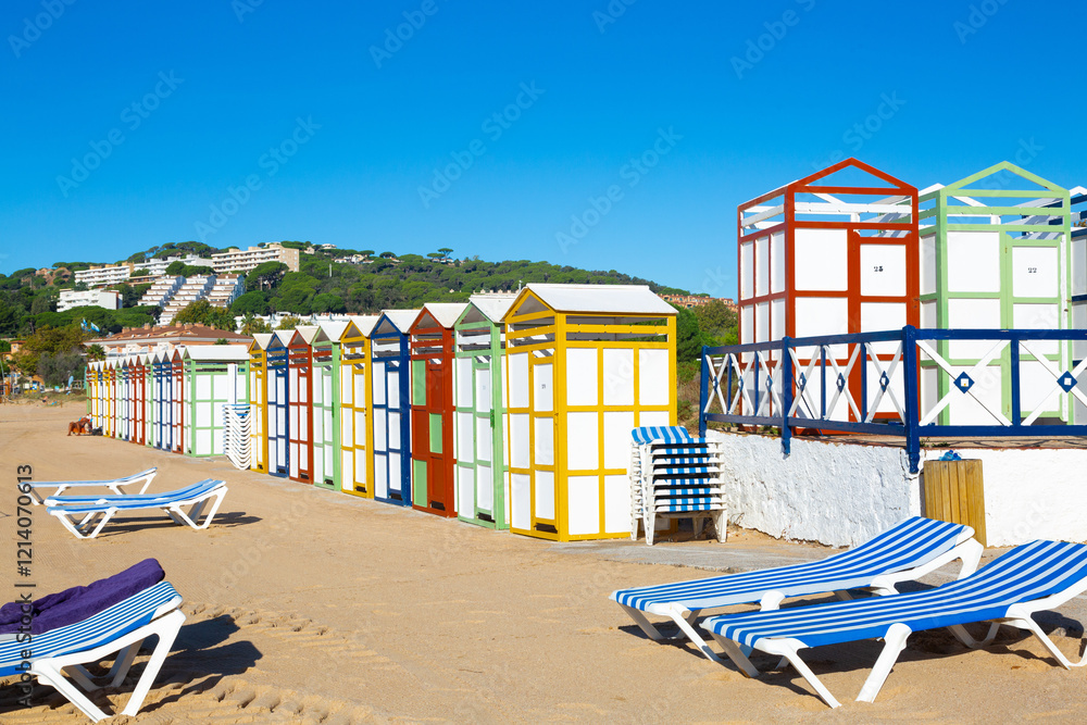 Colorful beach huts and sunbeds inviting tourists to relax on sandy shore