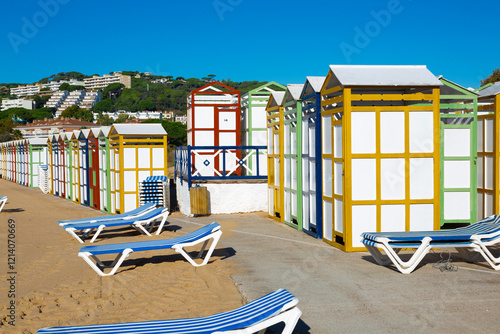 Obraz na płótnie Colorful beach huts and sunbeds inviting tourists to relax on sandy shore w salonie