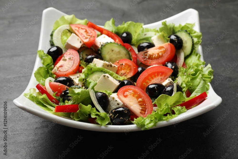 Delicious fresh Greek salad on black table, closeup Delicious fresh Greek salad on black table, closeup