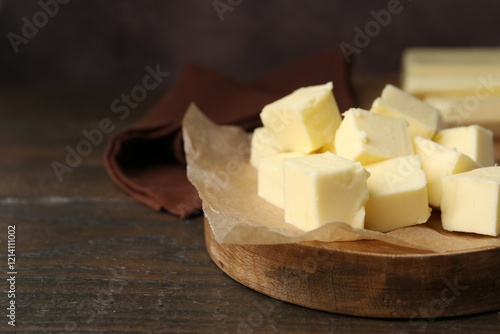 Pieces of fresh butter on wooden table, closeup. Space for text photo