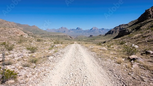 Desert road leading to mountains under a clear sky. Use Travel brochure