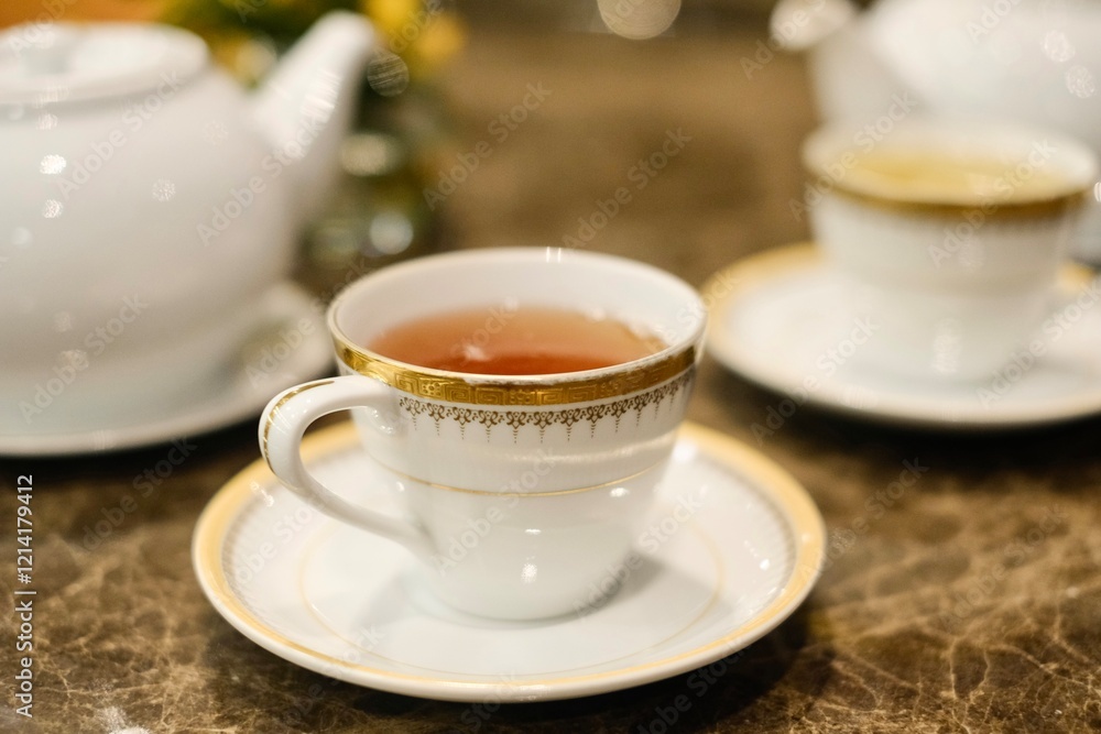 Fine bone china teacups with gold trim and two pots of tea: Taiwanese tie guan yin oolong and Japanese sencha, at the lounge of Montien Surawong, a hotel in Silom - Bang Rak, Bangkok, Thailand Fine bone china teacups with gold trim and two pots of tea: Taiwanese tie guan yin oolong and Japanese sencha, at the lounge of Montien Surawong, a hotel in Silom - Bang Rak, Bangkok, Thailand