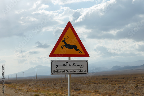 A caution sign indicates the presence of Goitered Gazelles along the Gorgan to Bojnord road in Golestan National Park, Iran, under a cloudy sky. photo