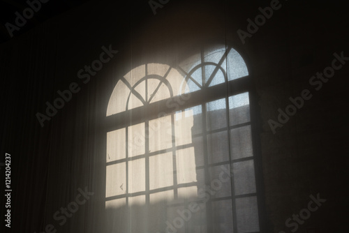 window light silhouette on the curtain given by the sunbeam entering the room. suggestive scenography with light games creates a surreal and romantic place. light filter creates a soft atmosphere.