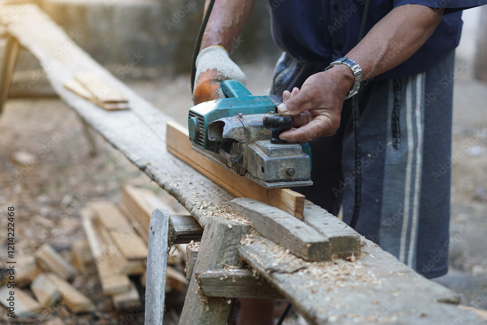 Closeup carpenter using electric planer with wooden plank in carpentry worksite. Concept, tool or equipment for construction work. Using with careful and skillful for safety. Closeup carpenter using electric planer with wooden plank in carpentry worksite. Concept, tool or equipment for construction work. Using with careful and skillful for safety.