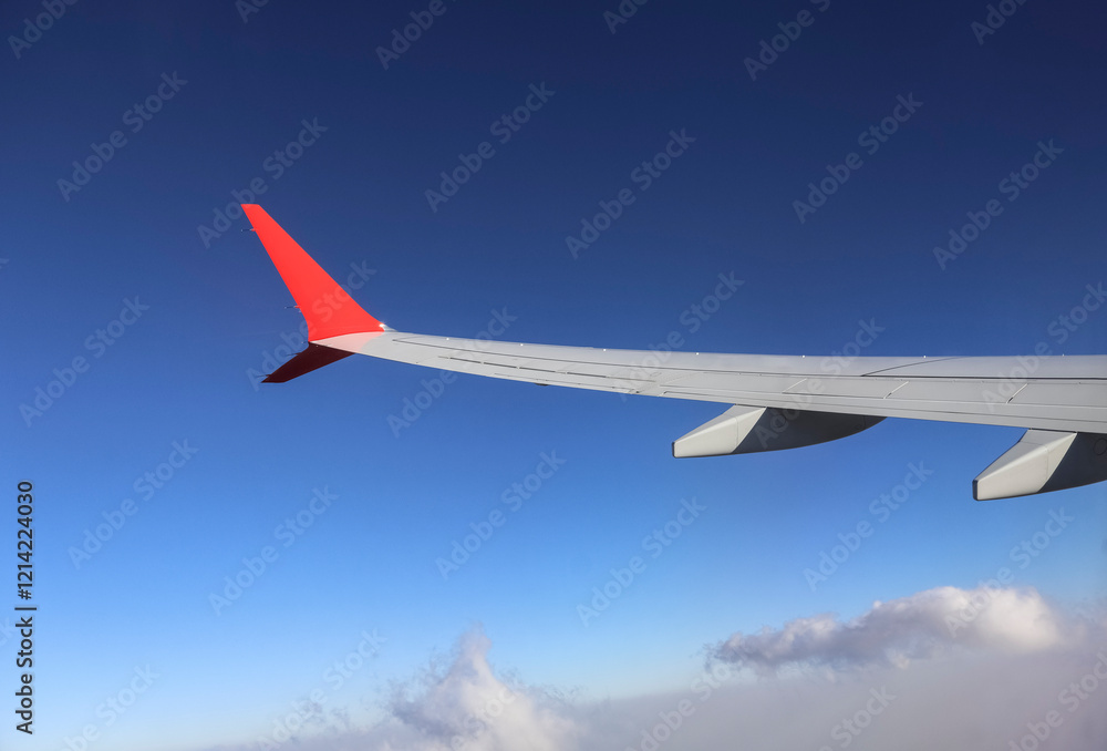 Fototapeta premium Traveling by plane - from the window of a passenger aircraft, the wing of an airplane. The concept of vacation, travel, logistics