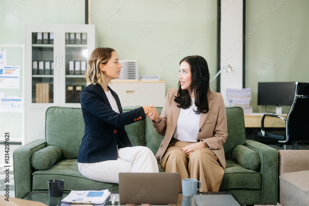 Fototapeta premium Two businesswomen collaborate using a tablet in a stylish office setting. Perfect for concepts