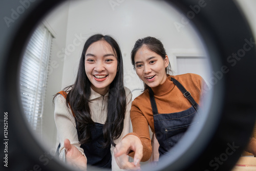 Couple selling clothes online, joyfully sharing ideas through a ring light lens in their contemporary home office photo