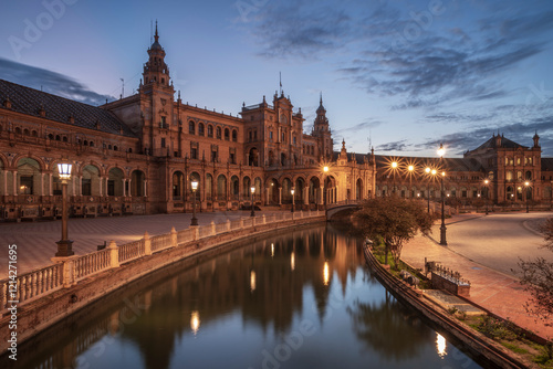 Plaza de Espana, Seville, Andalusia, Spain, at sunrise. The building is reflecting in the calm, smooth water.