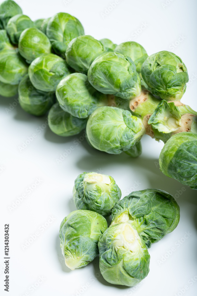 Fototapeta premium Green brussels sprouts on stalks on white table