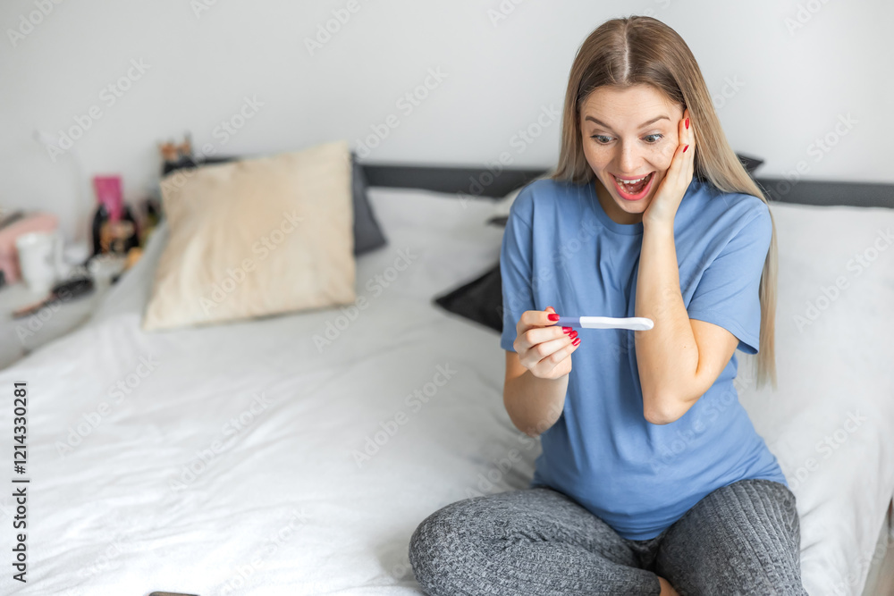 Young woman feeling happy after look at positive pregnancy test. Beautiful loving female feel happy and excited for good news to be future parent on bed in bedroom. Family-Expecting baby concept Young woman feeling happy after look at positive pregnancy test. Beautiful loving female feel happy and excited for good news to be future parent on bed in bedroom. Family-Expecting baby concept