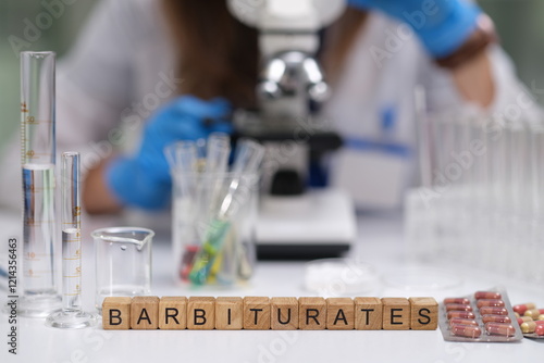 A focused laboratory setting that prominently showcases various barbiturates, test tubes, and a microscope photo