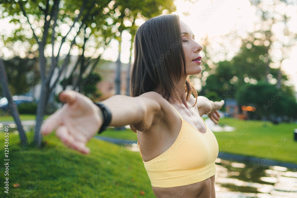 A Woman Embracing and Relishing the Beauty of Nature in a Lush Park During the Calmness of Sunrise A Woman Embracing and Relishing the Beauty of Nature in a Lush Park During the Calmness of Sunrise