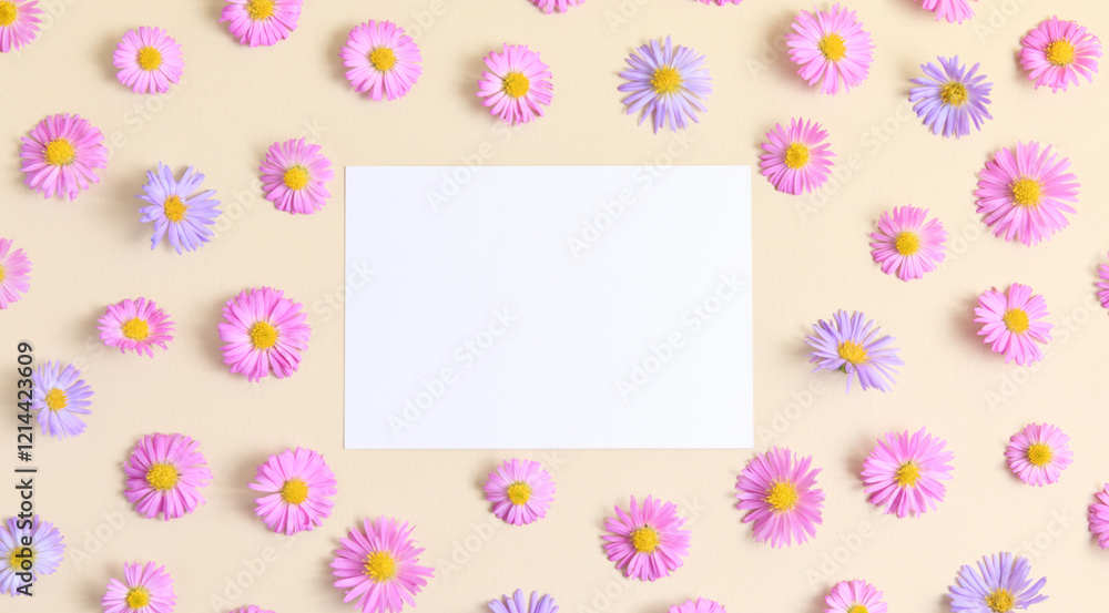 Greeting card template. Pink and purple flower aster on beige table background with blank paper sheet. Flat lay, top view, mockup, copy space for text. Aesthetic stylish floral pattern. Greeting card template. Pink and purple flower aster on beige table background with blank paper sheet. Flat lay, top view, mockup, copy space for text. Aesthetic stylish floral pattern.
