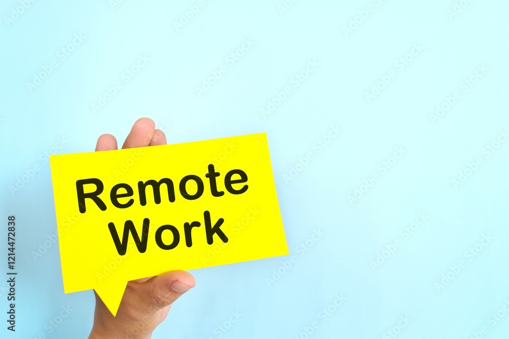 Human hand holding yellow speech bubble with written phrase Remote Work. Hiring for remote work setup.