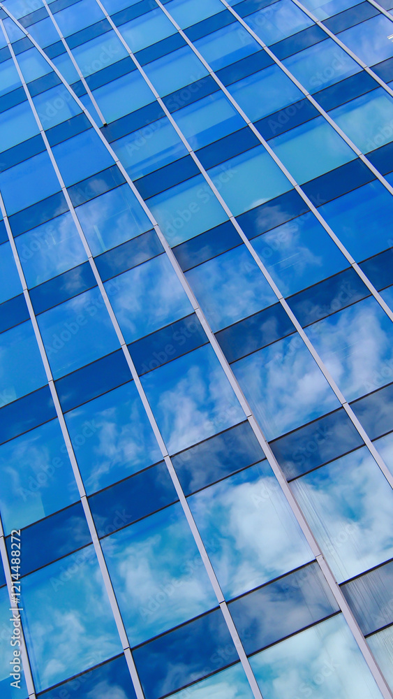 A stunning interplay of curved architectural lines and mirrored glass, capturing the soft patterns of drifting clouds. The juxtaposition of the building's structure against the dynamic sky A stunning interplay of curved architectural lines and mirrored glass, capturing the soft patterns of drifting clouds. The juxtaposition of the building's structure against the dynamic sky