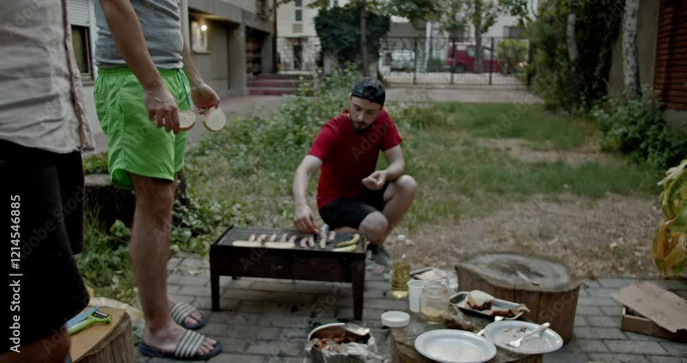 Friends grilling and eating in a rustic backyard. They are having fun together on a summer day. Friends grilling and eating in a rustic backyard. They are having fun together on a summer day.