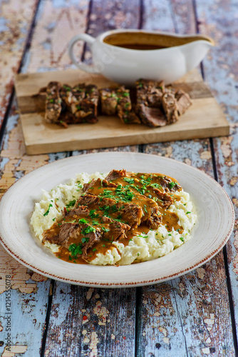 sliced pot roast on a bed of mashed potatoes photo