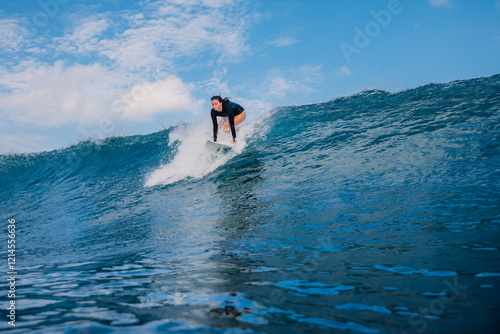 Surfer woman on surf board during tropical surfing. Surfer girl pop up on ocean wave photo