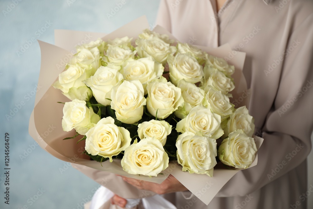 Woman holding luxury bouquet of fresh roses on light blue background, closeup Woman holding luxury bouquet of fresh roses on light blue background, closeup