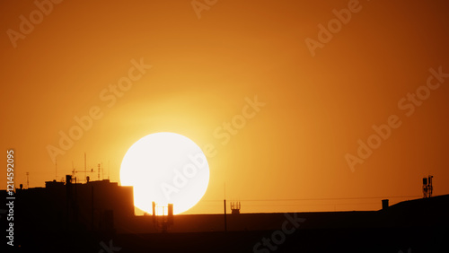 Fototapeta Naklejka Na Ścianę i Meble -  Big sun and a view of the rooftops of the city