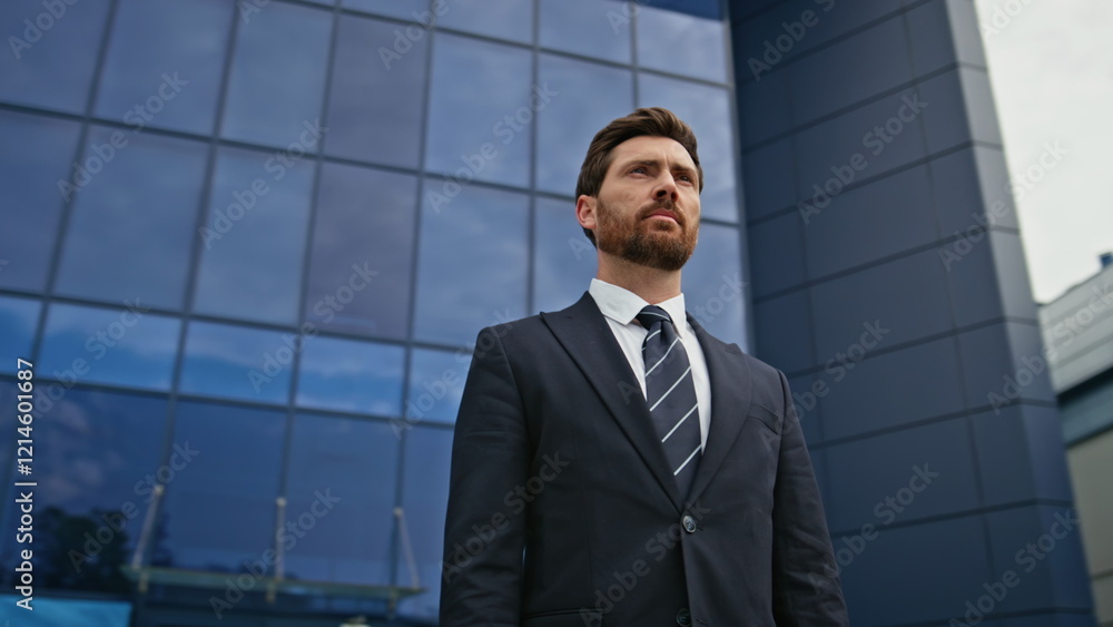 Serious boss standing outside modern office with confident expression closeup. Serious boss standing outside modern office with confident expression closeup.