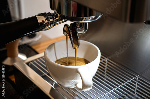 Close-up of espresso pouring from the coffee machine into a coffee cup. Professional coffee brewing