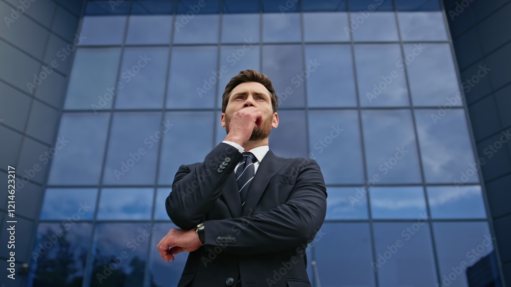 Bearded executive standing street deep in thought near glass office wall closeup Bearded executive standing street deep in thought near glass office wall closeup