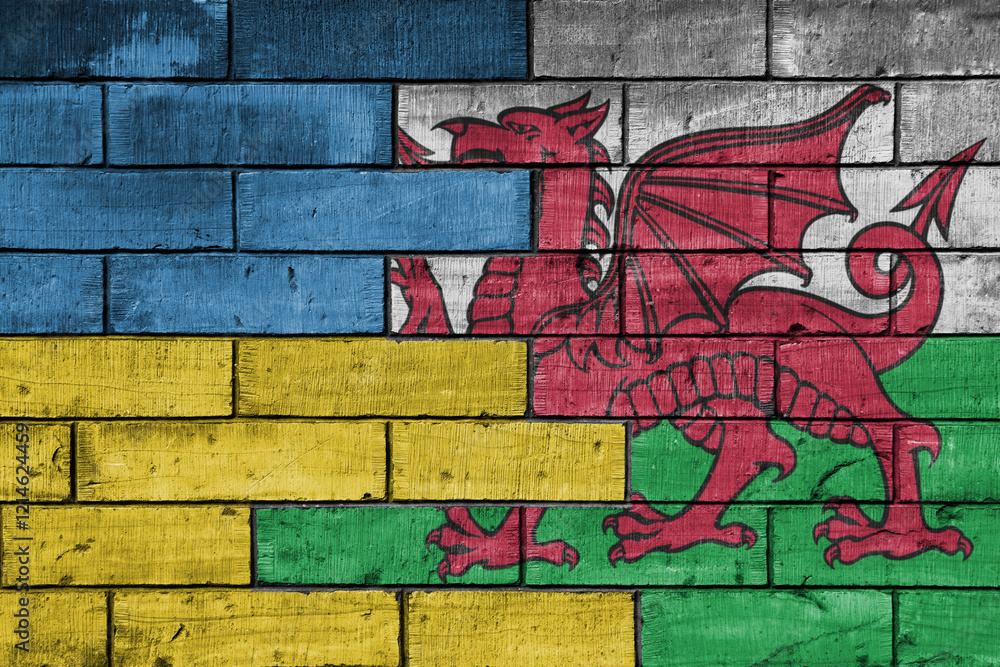 colourful painted big flag of ukraine and flag of wales on a massive old brick wall background. concept colourful painted big flag of ukraine and flag of wales on a massive old brick wall background. concept