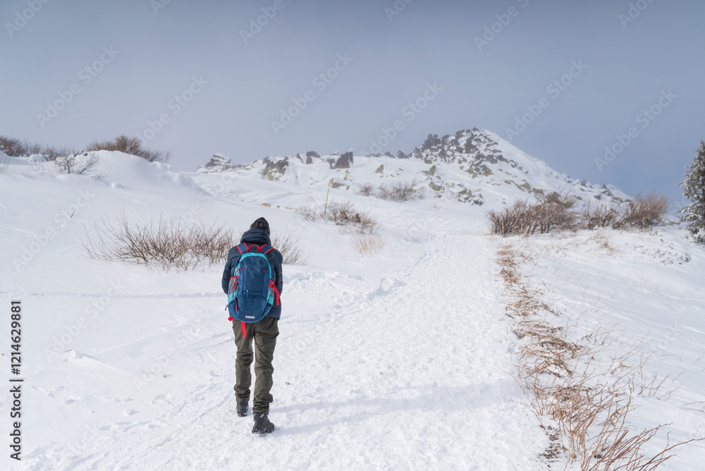 Senior man hiking in the winter snowy mountain Senior man hiking in the winter snowy mountain