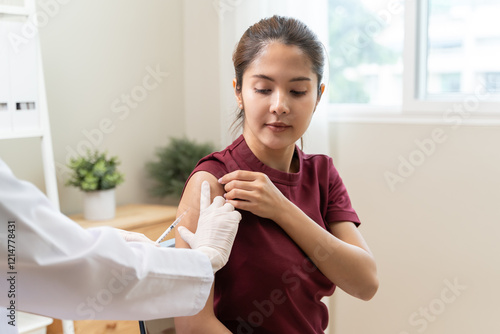 People getting a vaccination to prevent pandemic concept. Woman in medical face mask  receiving a dose of immunization coronavirus vaccine from a nurse at the medical center hospital
