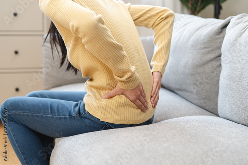 Canvastavla Close-up woman massaging her lower back has back pain because of sitting posture during work in office