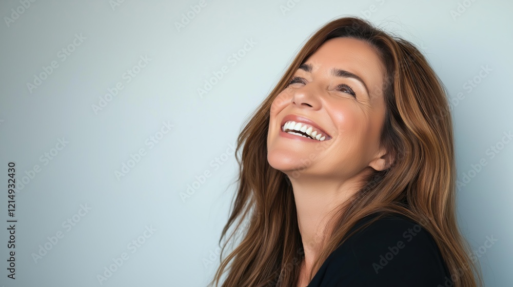 Portrait of a woman laughing and looking up against a neutral background with copyspace Portrait of a woman laughing and looking up against a neutral background with copyspace