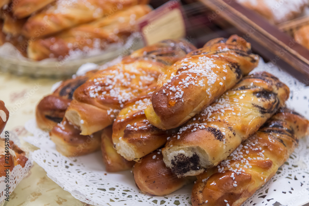 A variety of sweet pastries are beautifully arranged in a local bakery. These treats attract customers with their golden color and sugary toppings, perfect for an afternoon snack. A variety of sweet pastries are beautifully arranged in a local bakery. These treats attract customers with their golden color and sugary toppings, perfect for an afternoon snack.