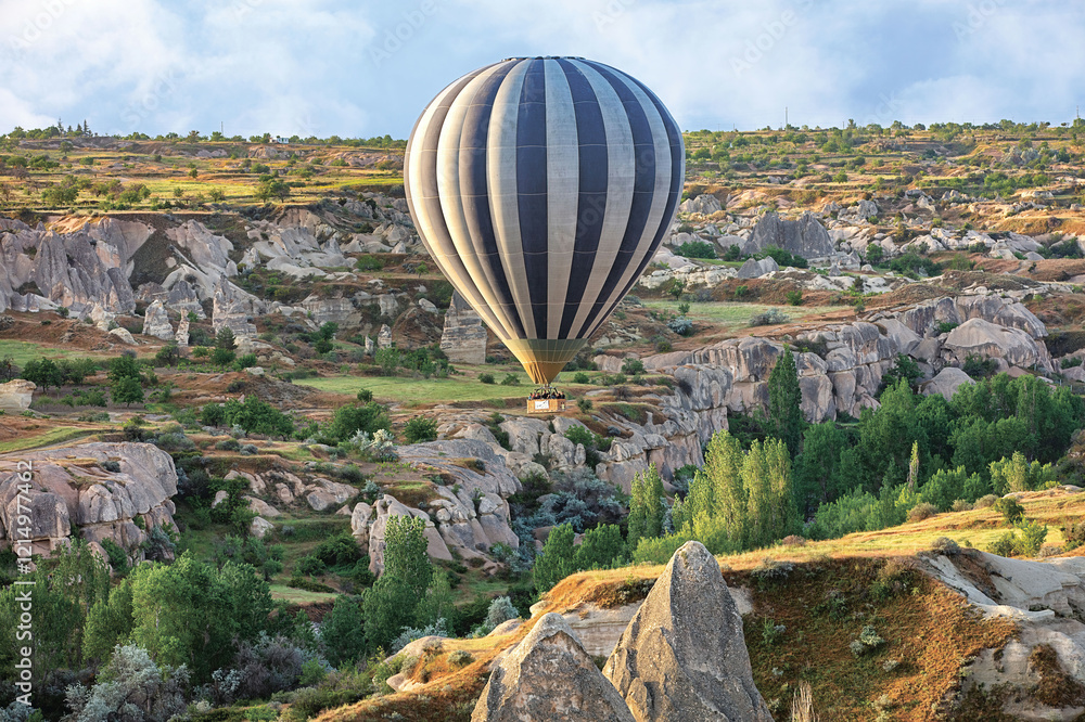 Hot air balloon floating over the stunning landscapes of Cappadocia in the early morning light