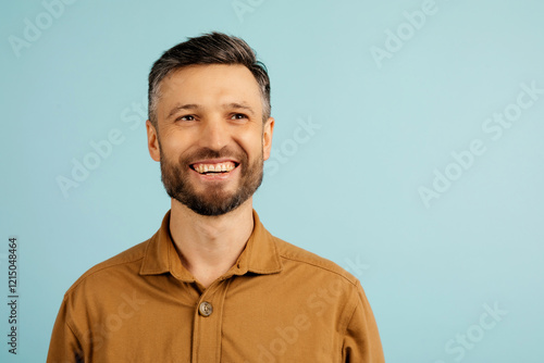 Pensive middle aged man thinking, looking aside at free space, posing on blue studio background. Let me think concept. High quality photo