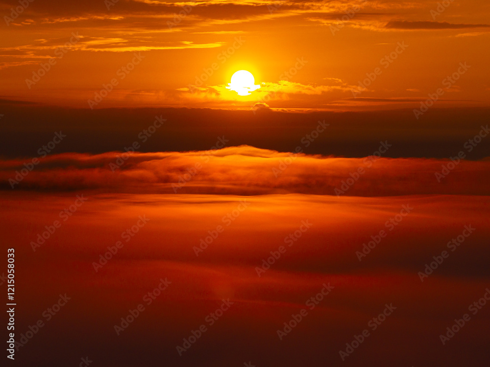 A breathtaking sunrise above a sea of clouds, capturing vibrant orange and yellow hues in the sky. Amazing sunrise photo aerial view between layers of clouds, landscape photo.