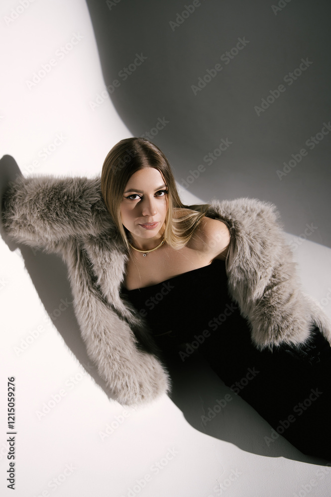 Portrait of a woman in a studio with professional lighting in a smart dress with gloves and a fur coat
