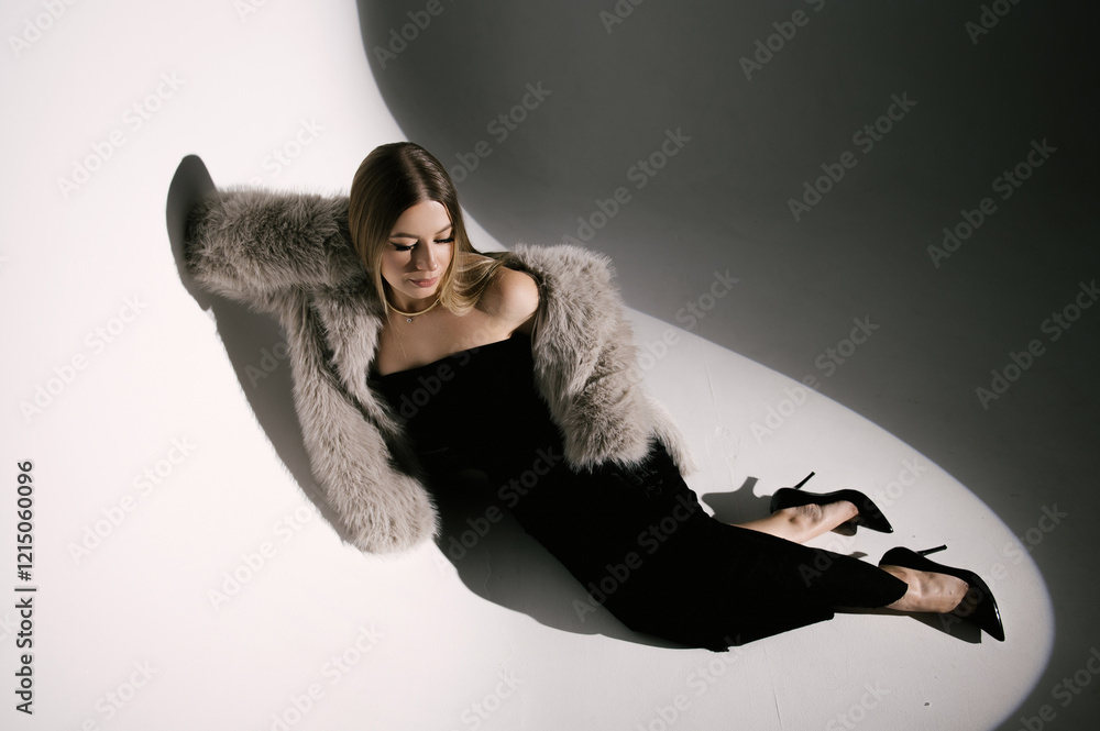 Portrait of a woman in a studio with professional lighting in a smart dress with gloves and a fur coat