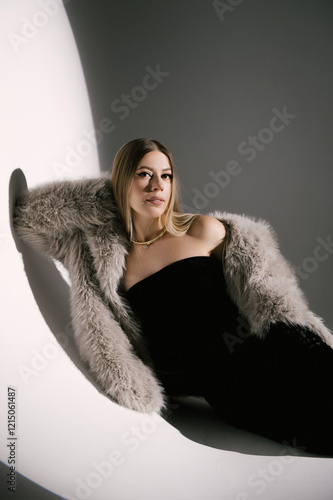 Portrait of a woman in a studio with professional lighting in a smart dress with gloves and a fur coat